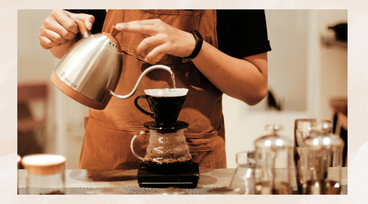 An image of someone pouring hot water into a v60 funnel with v60 filter paper placed on top